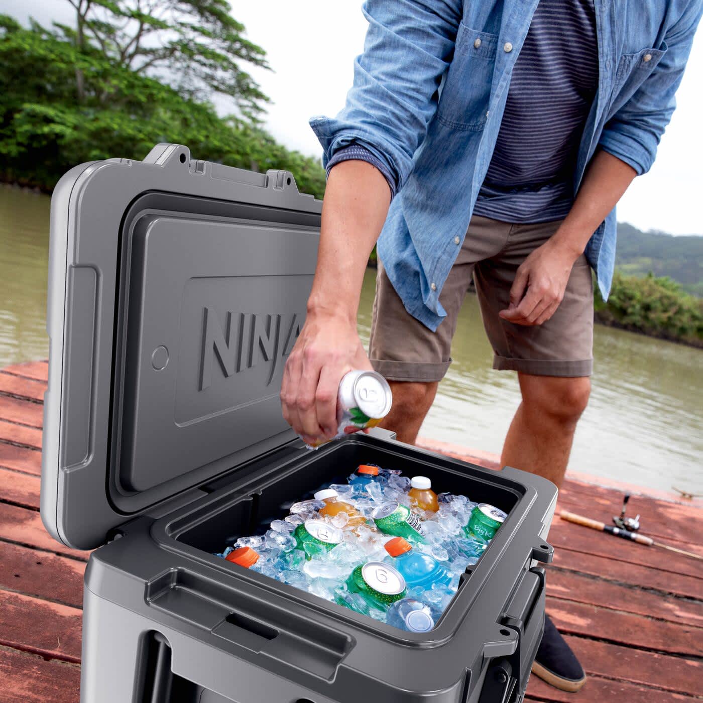 Person nimmt eine Getränkedose aus der eisgefüllten Ninja FrostVault Kühlbox Person nimmt eine Getränkedose aus der eisgefüllten Ninja FrostVault Kühlbox