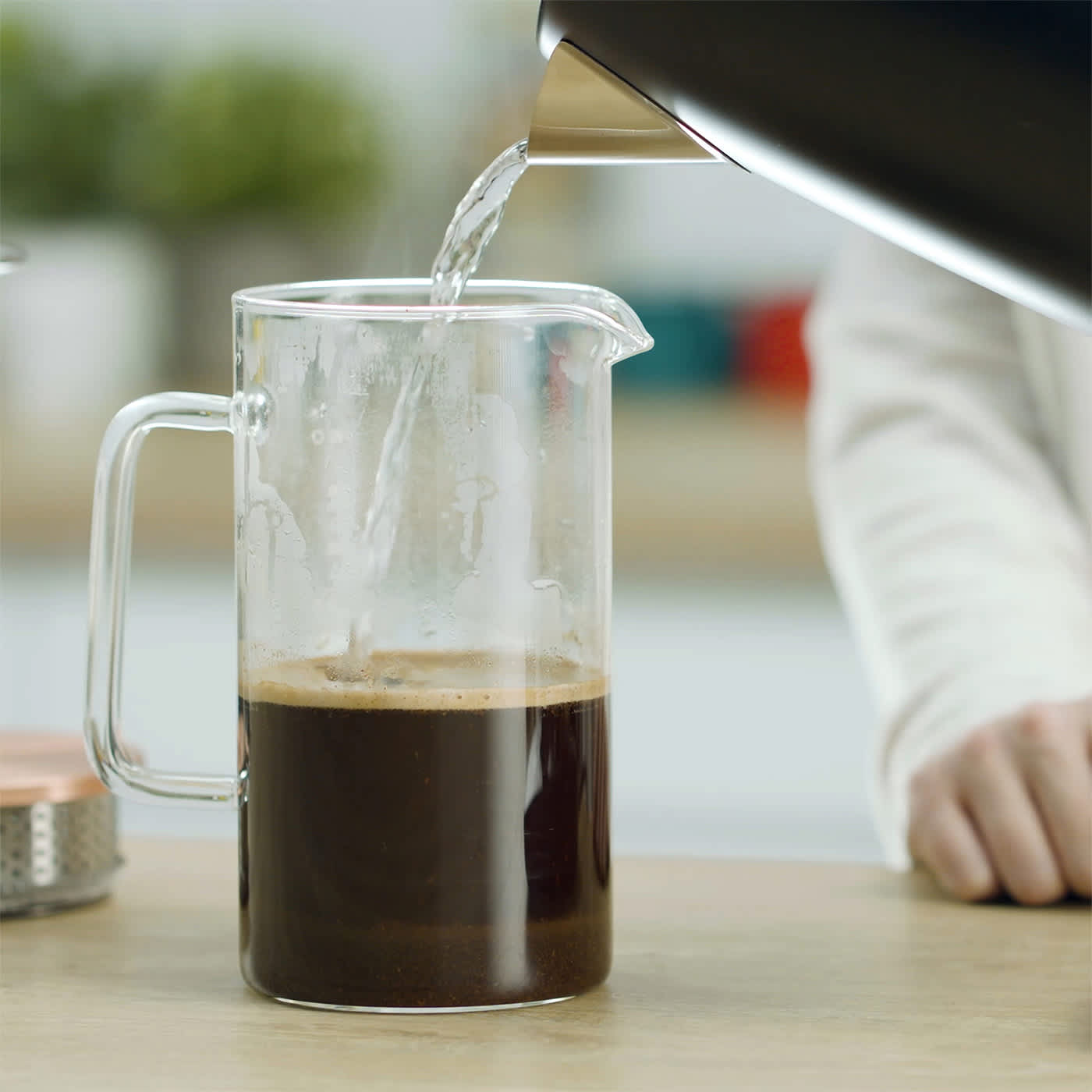 Person gießt heißes Wasser aus dem Ninja Wasserkocher KT200EU in ein Behälter, um Kaffee aufzugießen. Person gießt heißes Wasser aus dem Ninja Wasserkocher KT200EU in ein Behälter, um Kaffee aufzugießen.